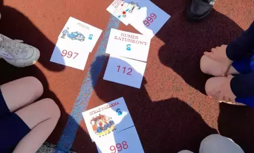 Uczniowie z numerami alarmowymi.