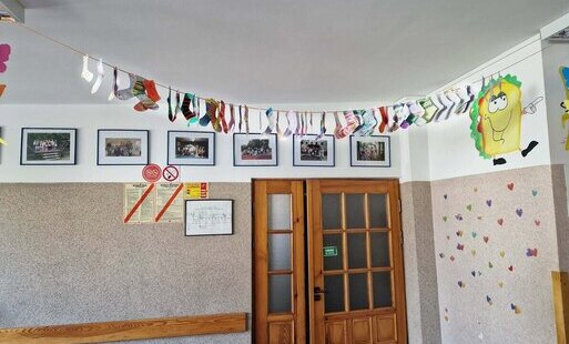 Papierowe skarpetki wiszące na sznurku w holu szkolnym.